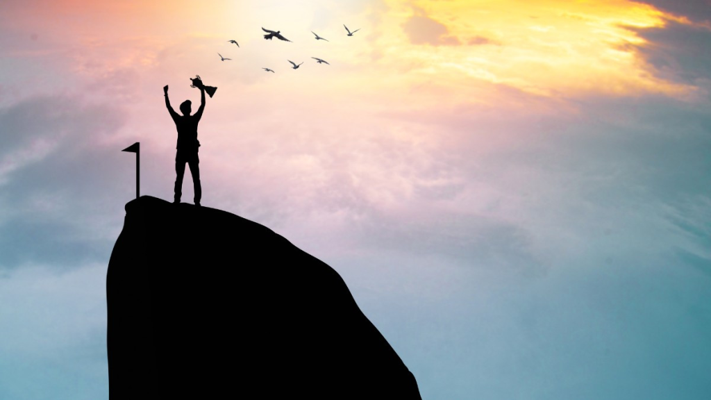 A person happily holding a trophy after reaching the top of a cliff.